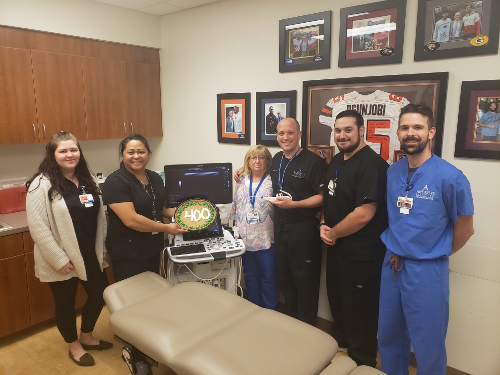 Dr. Brett Kindle celebrating 400 UltraGuideCTR procedures with his team.